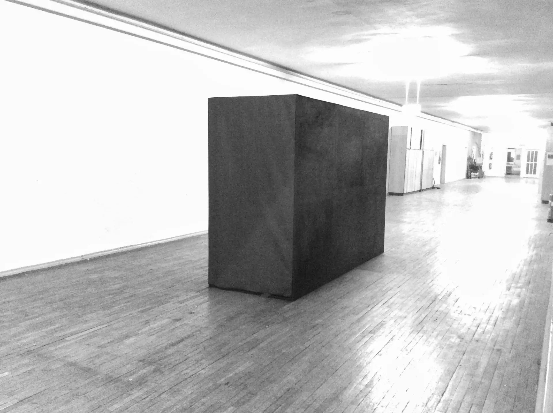Black rectangular passage installed in a white gallery space.