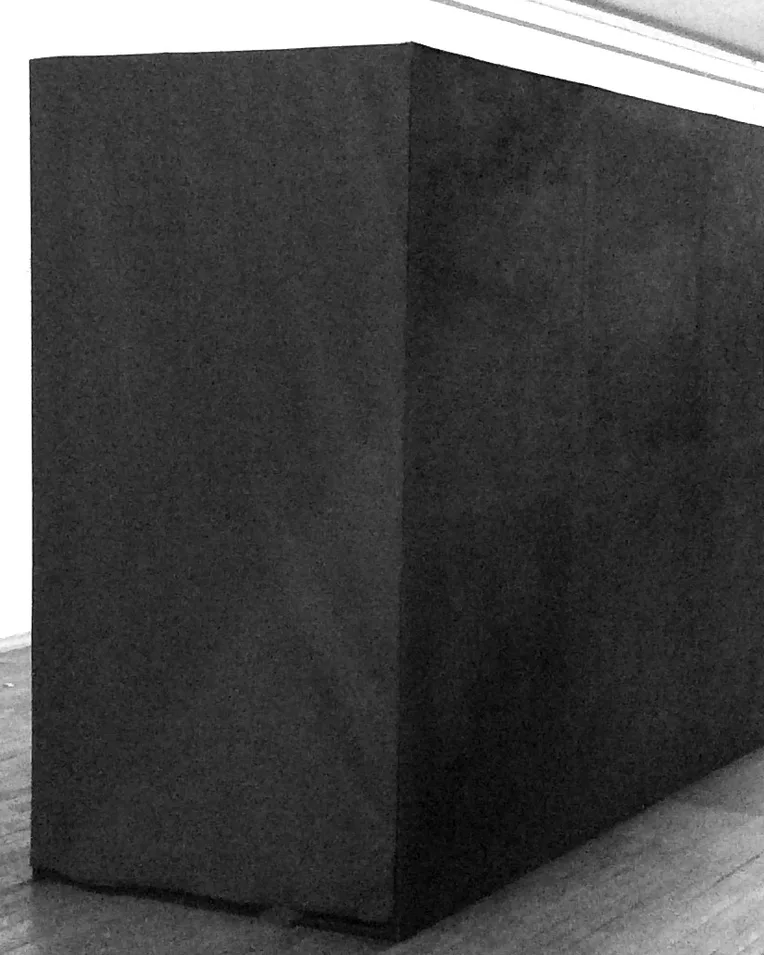 Black rectangular passage installed in a white gallery space.